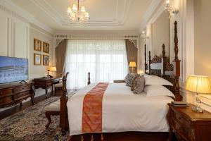 Ping Pura Riverside Resort & Spa Chiang Mai في شيانغ ماي: غرفة نوم بها سرير كبير وتلفزيون