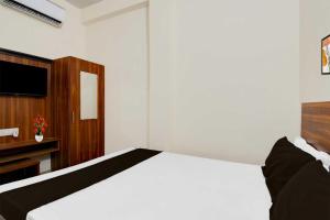 a bedroom with a bed and a television in it at Hotel O Sultanpur Railway Junction Formerly Sanskar Marriage Lawan in Sultānpur