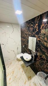 a bathroom with two sinks and a marble wall at Winter Cloud in Mahabaleshwar +6 photos