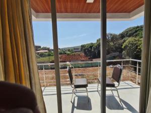 two chairs sitting on a balcony looking out the window at Winter Cloud in Mahabaleshwar