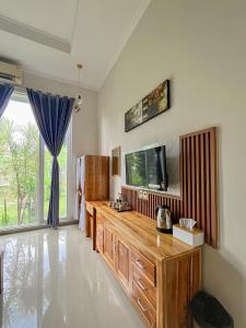 a living room with a tv and a large window at Omah Ulfah Homestay in Banyuwangi