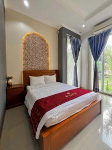 a bedroom with a large bed with a large window at Omah Ulfah Homestay in Banyuwangi