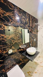 a bathroom with a black and gold marble wall at Winter Cloud in Mahabaleshwar