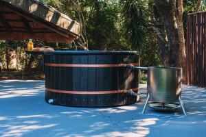 a barrel and a bucket sitting on the ground at The Grand Luxury Safari Villa, Huge Private Pool, Hottub, Outdoor Shower, Giraffe Tower in Hluhluwe