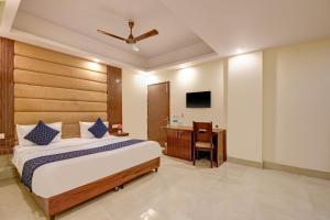 ein Schlafzimmer mit einem Bett, einem Schreibtisch und einem Fernseher in der Unterkunft Hotel Key Residency Near Delhi Airport kapashera in Neu-Delhi