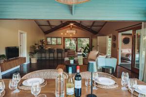 a table with wine glasses and a living room at The Grand Luxury Safari Villa, Huge Private Pool, Hottub, Outdoor Shower, Giraffe Tower in Hluhluwe