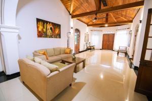 ein Wohnzimmer mit Sofa und Tisch in der Unterkunft Heritage Kandy City Bungalow in Kandy
