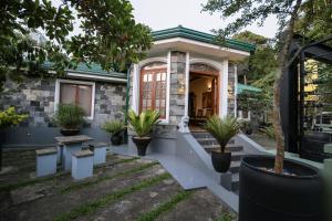 ein Haus mit Topfpflanzen auf der Veranda in der Unterkunft Heritage Kandy City Bungalow in Kandy