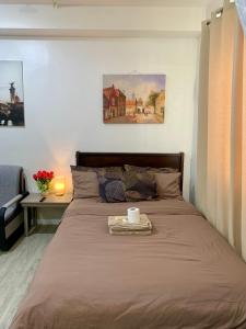 a bed with a tray with a cup on it at Cozy Condominium at Amaia Steps Nuvali in Pitland