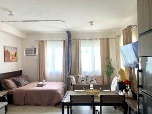 a living room with a bed and a couch at Cozy Condominium at Amaia Steps Nuvali in Pitland +12 photos