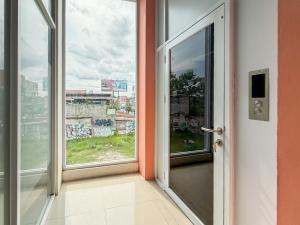 eine offene Tür zu einem Zimmer mit Fenster in der Unterkunft Sans Stay Harmoni 88 Ambarukmo Plaza Yogyakarta in Adi Sutjipto