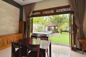 a dining room with a table and a large window at Arisa Villa by AGATA in Menanga