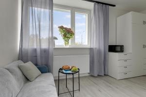 a living room with a couch and a window at Gdynia Campus in Gdynia