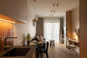 a kitchen and living room with a table and a couch at Trevi Apartments Katowice - City Center - Spodek MCK NOSPR in Katowice