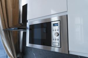 a stainless steel microwave oven in a kitchen at Lovely 1BR & 1LR Apartment, Only 15 Min Walk to City Center in Ghent +25 photos