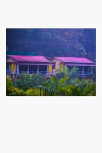 a house with pink roofs on top of it at Vantara jungle stay in Potolai +9 photos