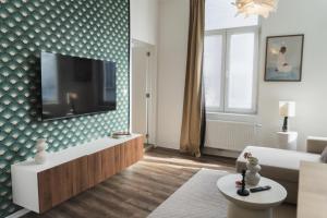 a living room with a flat screen tv on a wall at Lovely 1BR & 1LR Apartment, Only 15 Min Walk to City Center in Ghent