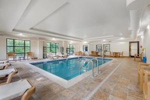 a large indoor pool with chairs and a table at Comfort Suites Lewisburg in Lewisburg