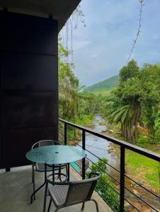 アビッサウェッラにあるHeaven De Fountainのテーブルと椅子、川の景色を望むバルコニー