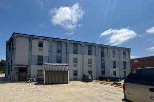 a large white building with a car parked in a parking lot at Gallus Stadium Park Inn, an Ascend Collection Hotel in Columbia