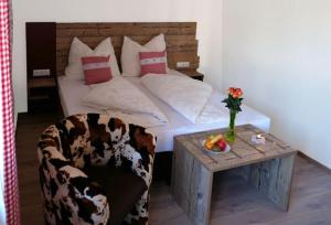 a bedroom with a bed and a table with a chair at Jochberger Dorfstubn in Jochberg