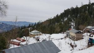 a group of buildings on a snow covered mountain at Kashmir Heights Hotel & Restaurant in Dargai