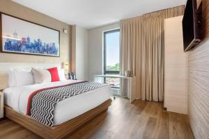 a hotel room with a bed and a television at Insignia Hotel Brooklyn, an Ascend Collection Hotel in Brooklyn +58 photos