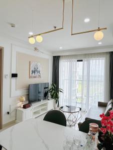 un salon avec une télévision et une table dans l'établissement Minh Anh Apartment 3, à Thôn An Hòa