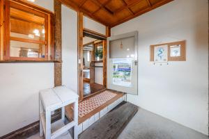 a room with a door and a bench in it at Peace Garden Furano in Nakafurano