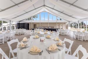 a banquet hall with white tables and chairs at Traditions Hotel & Spa Johnson City - Binghamton, an Ascend Collection Hotel in Johnson City