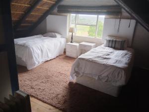 a bedroom with two beds and a window at Rivers edge cottage in Stilbaai