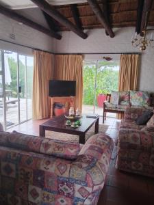 un salon avec un canapé et une table dans l'établissement Rivers edge cottage, à Stilbaai