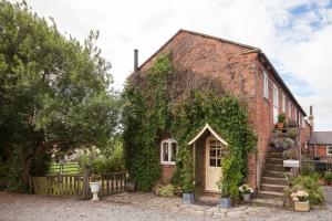 Green HammertonにあるSkipbridge Farm Cottagesの白い扉と蔦のレンガ造り