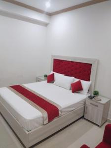 a bedroom with a large bed with a red headboard at Dream Palace Hotel in Dargai