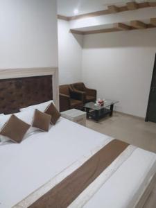 a bedroom with a large bed and a table at Dream Palace Hotel in Dargai