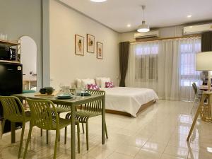 een slaapkamer met een bed, een tafel en stoelen bij The Giftown Vientiane, Ban Anou in Vientiane