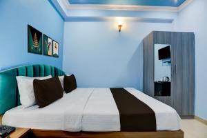 a bedroom with a large bed with blue walls at Hotel O kumar inn in Lok Nayak Jayaprakash Airport