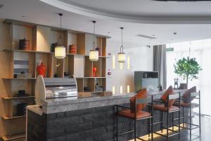 保山保山嘉悦兰庭万信至格酒店的厨房设有配有椅子和灯具的酒吧