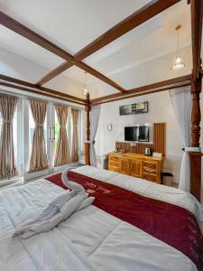 a large bedroom with a large bed and a tv at Omah Ulfah Homestay in Banyuwangi