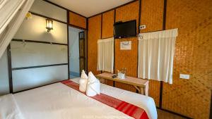 una camera d'albergo con un letto e una televisione di Pai Vintage Garden Resort a Pai