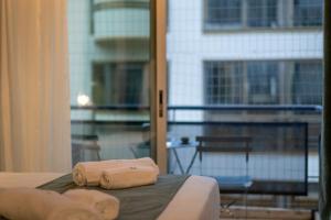two towels sitting on top of a bed in front of a window at Urban Nest in Kalamata