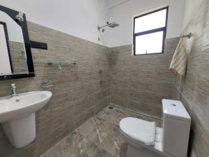 a bathroom with a sink and a toilet and a window at Paboda Residency in Minuwangoda