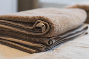 a stack of brown towels sitting on top of a bed at Lovely 1BR & 1LR Apt for 4P, Only 15 Min Walk to City Center in Ghent