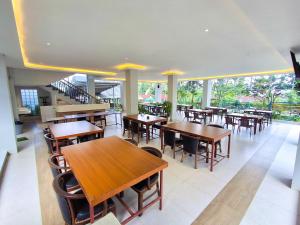 an empty restaurant with wooden tables and chairs at Hotel Kebon Kana Kaliurang in Kaliurang
