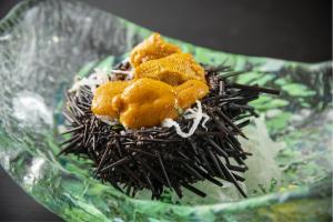 Echizen越前温泉 平成的一个装满食物的绿色玻璃碗放在上面