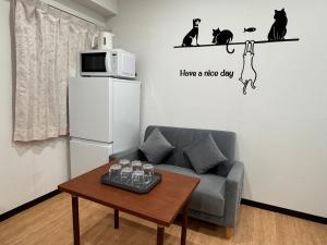 a living room with a couch and a microwave at 四季安々2号店 in Kawaguchi
