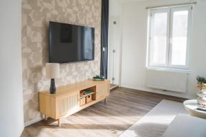 a living room with a flat screen tv on a wall at Lovely 1BR & 1LR Apt for 4P, Only 15 Min Walk to City Center in Ghent