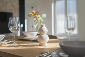 a table with a white vase with a flower in it at Lovely 1BR & 1LR Apt for 4P, Only 15 Min Walk to City Center in Ghent +32 photos