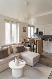 a living room with a white couch and a table at Lovely 1BR & 1LR Apt for 4P, Only 15 Min Walk to City Center in Ghent