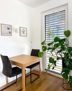 uma sala de jantar com uma mesa de madeira e uma planta em Modern Studio Gardenia_Gartenwohnung Alte Donau em Viena